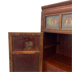 Late 19th century Chinese Qing dynasty red and black lacquered wood cabinet,  Fujianese province, upper cupboard enclosed by two doors with relief carved and gilt panels depicting figures behind glass, the large cupboard enclosed by two panelled doors carved with trailing foliate branches and birds, inscribed with Chinese characters, to the left ‘The red mountains are in the shape of Phoenixes and appear auspicious’ and to the right, ‘Wealth and honour are given by flowers and I hear the sound of the phoenix', fitted with two drawers, on square supports with carved brackets 