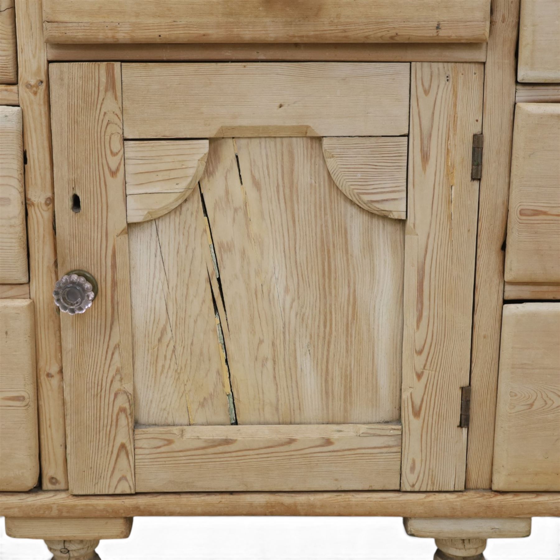 Victorian waxed pine farmhouse dresser, featuring seven drawers with central cupboard, moulded glass handles, raised on turned feet