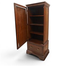 Willis & Gambier - hardwood swing mirrored door cabinet, in a dark cherrywood finish with moulded cornice over mirrored door incorporating adjustable cheval mirror action, enclosing a shelved interior, lower drawer with brass knob handles, panelled sides and stepped plinth base