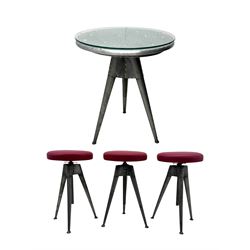 Contemporary industrial design riveted metal table, by repute fashioned from salvaged aeroplane parts, with a circular glass top on a tripod base, accompanied by three adjustable stools upholstered in burgundy