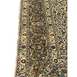 Persian Meshed carpet, ivory ground and decorated with intricate floral design with trailing scrolled branch, the central medallion decorated with stylised plant motifs, seven band border, the main band decorated with scrolls and flower head motifs