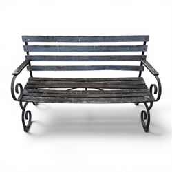 19th century wrought iron strapwork and slatted wood garden bench, the arm terminals and end supports of scrolling form