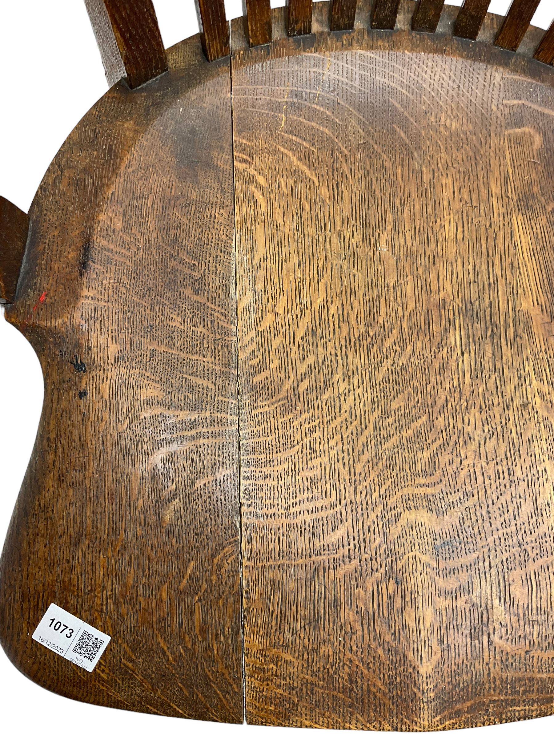 Early 20th century swivel office desk chair, shaped bar back over vertical rails, dished seat, on four splayed supports