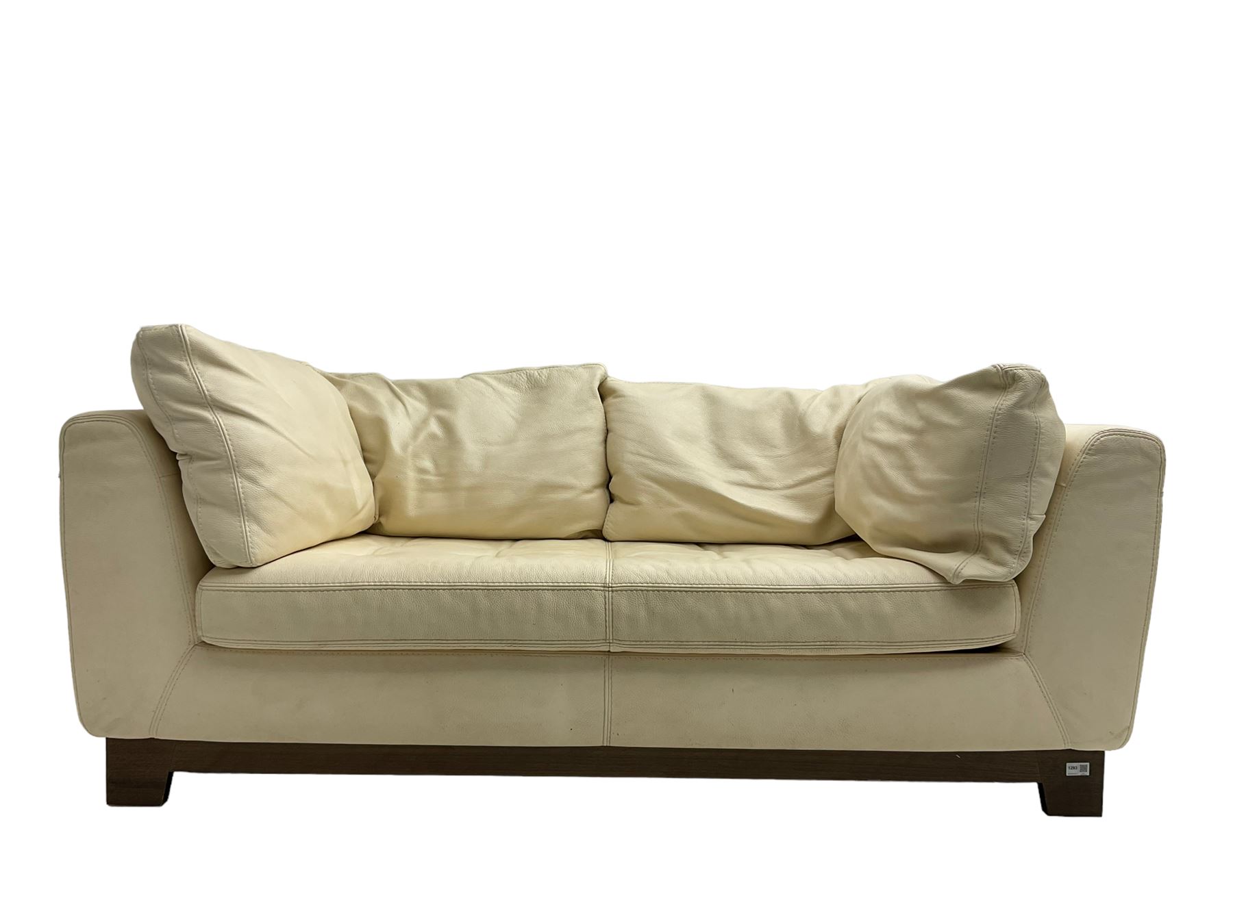 Roche-Bobois - two seat sofa, upholstered in ivory leather with buttoned seat cushions, raised on a stained beech base with bracket feet