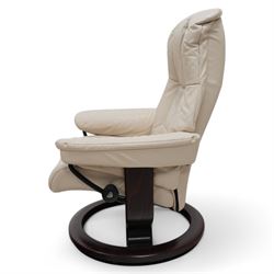 Ekornes - Stressless chair with stool, with padded arms and high backrest, raised on a circular mahogany-stained swivel base, fitted with reclining tension adjustment handle, supplied with stool with a lighter wood base 