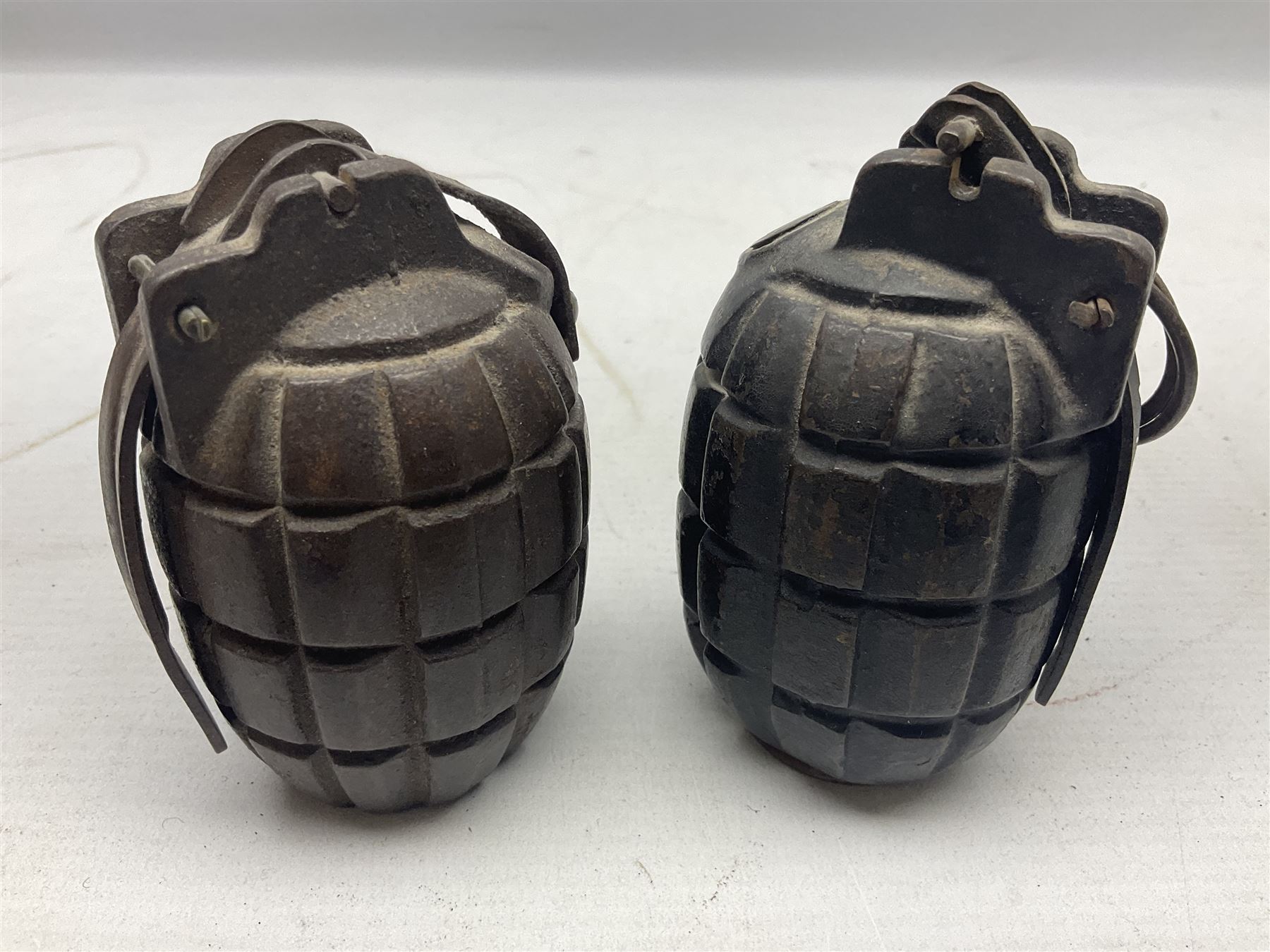 Two inert WW2 Mills Bomb (pineapple) hand grenades; one adapted as a money box with coin slit to the side and later cap H9.5cm (2)