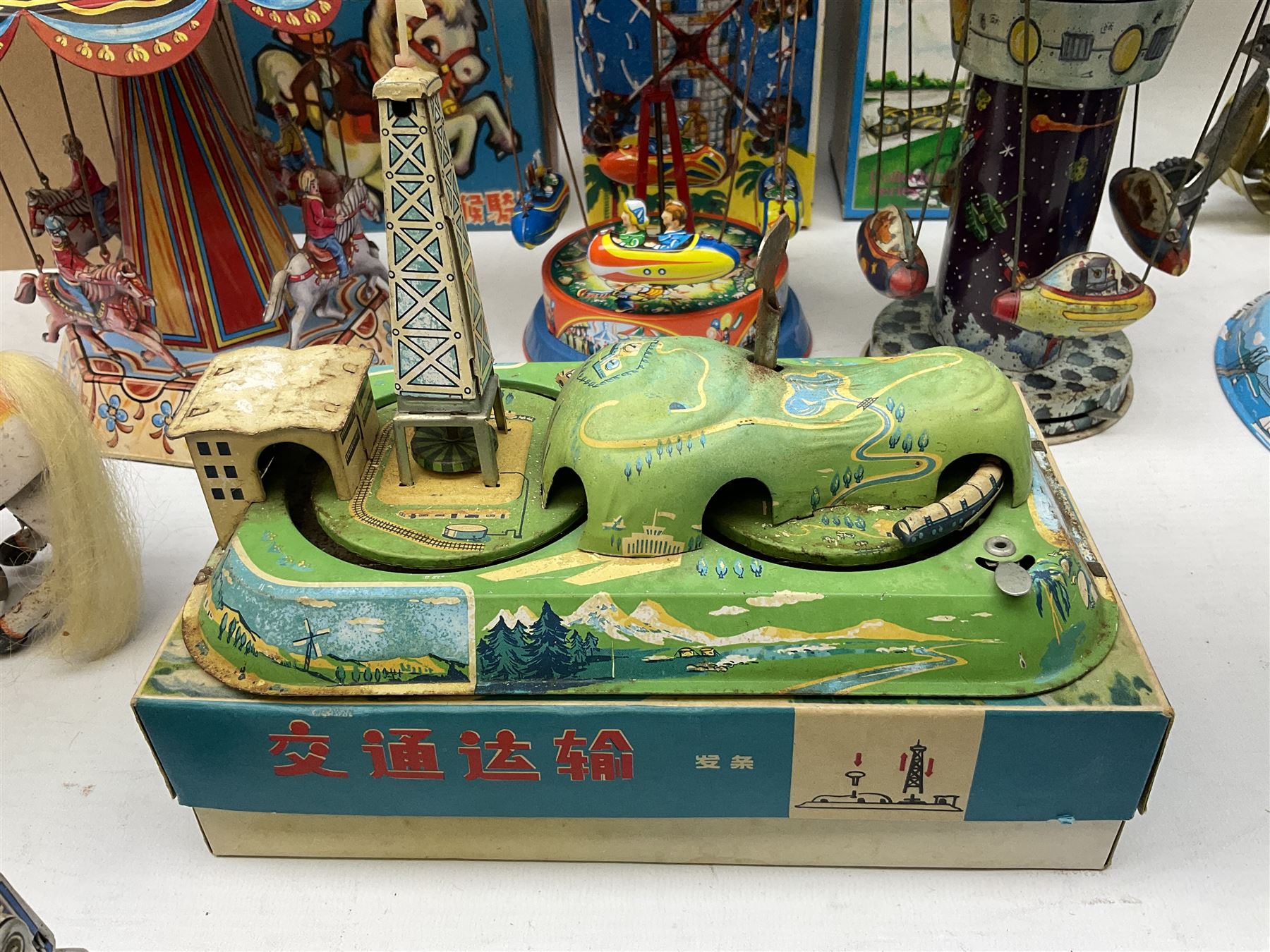 Mid 20th century and later tin plate clockwork toys, to include merry-go-rounds, spaceship carousel, walking robot, Schylling airport control tower, monkey riding horse, astronaut space station etc, including German and Japanese examples, some with boxes (12)