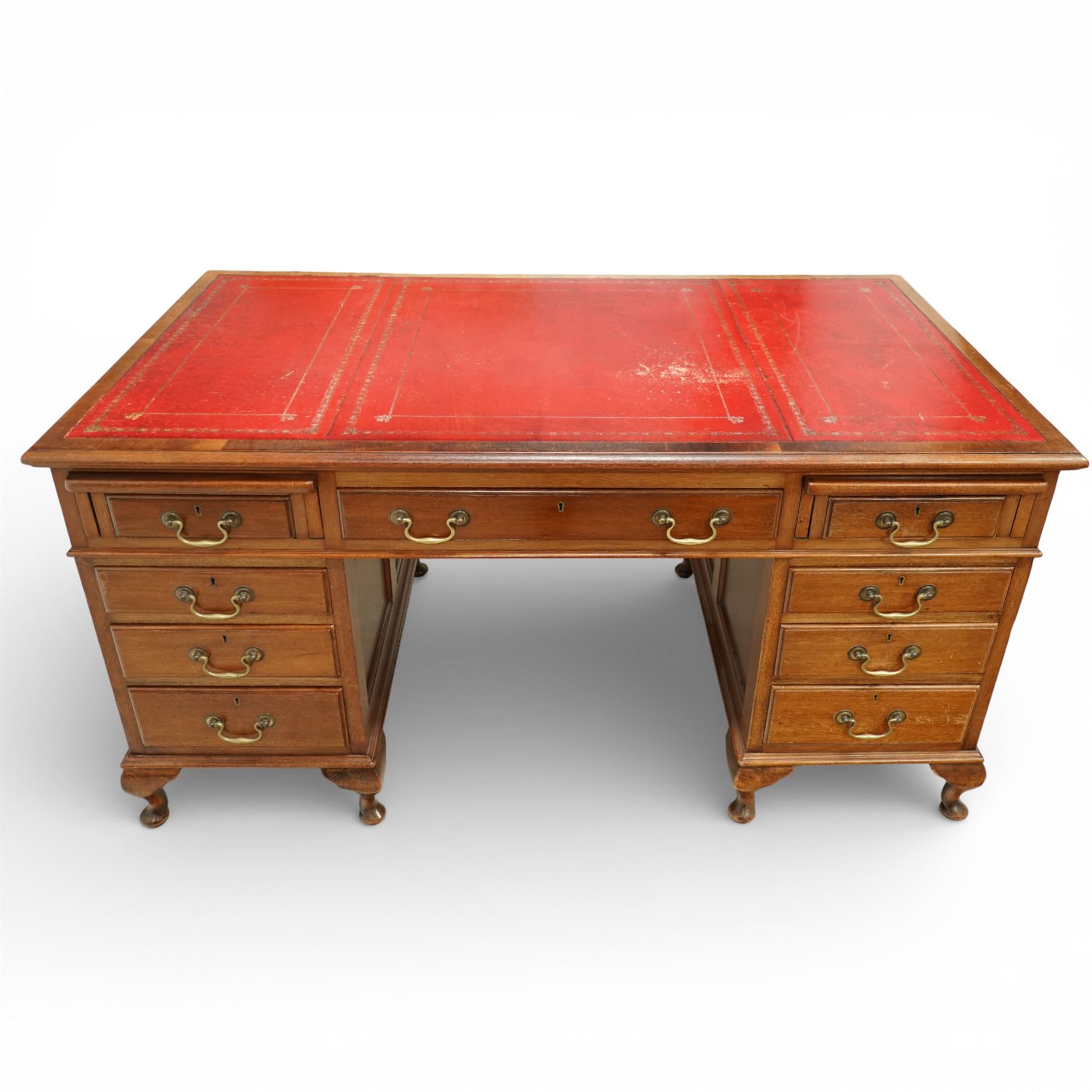 Late 19th century mahogany pedestal desk, rectangular top inset with worn red leather writing surface with gilt tooling, three frieze drawers above opposing pedestals each fitted with four graduated drawers, brass swan neck handles and escutcheons, panelled sides and back, raised on turned feet
