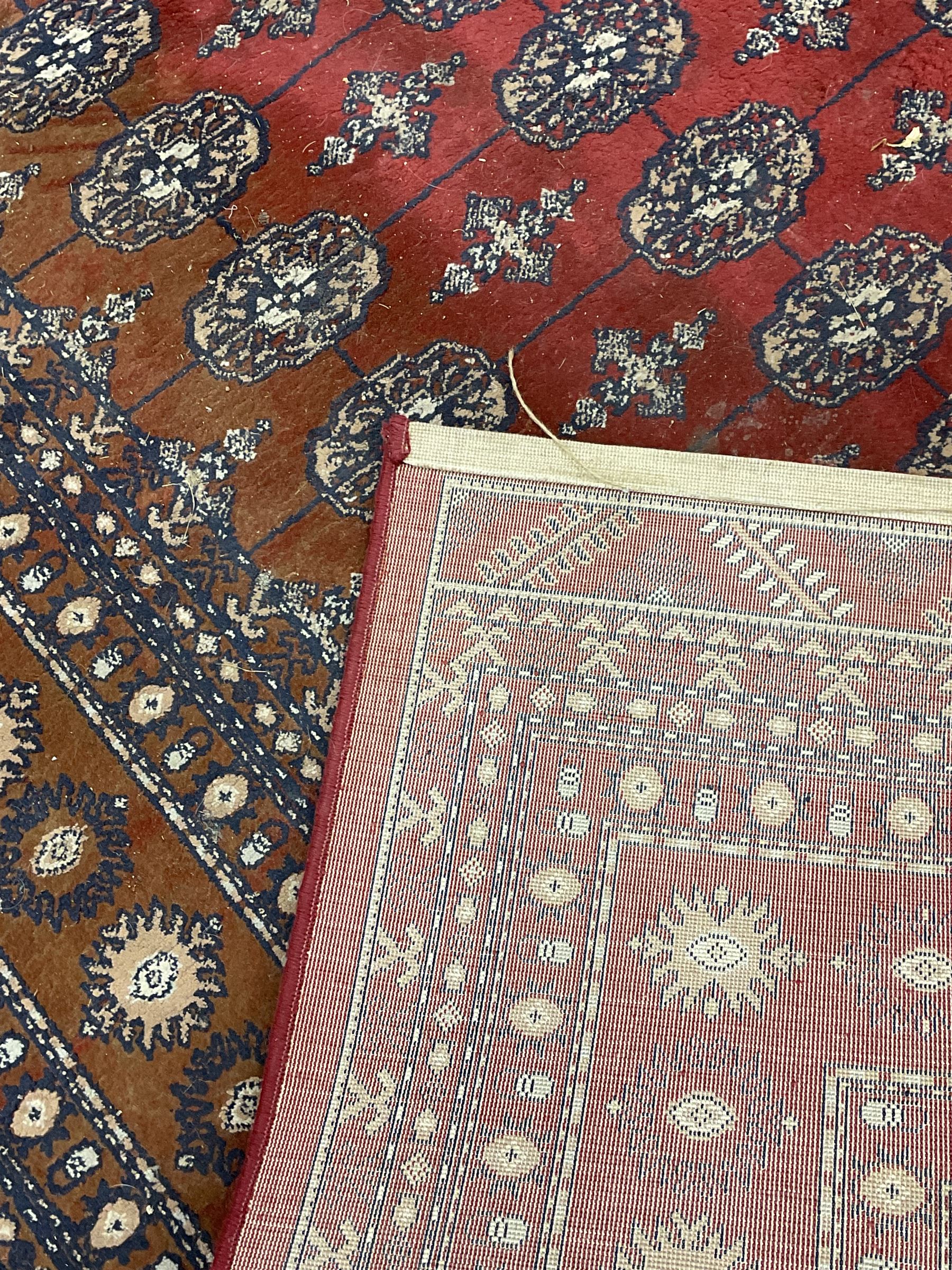 Persian Bokhara design rug, red ground and decorated with five rows of