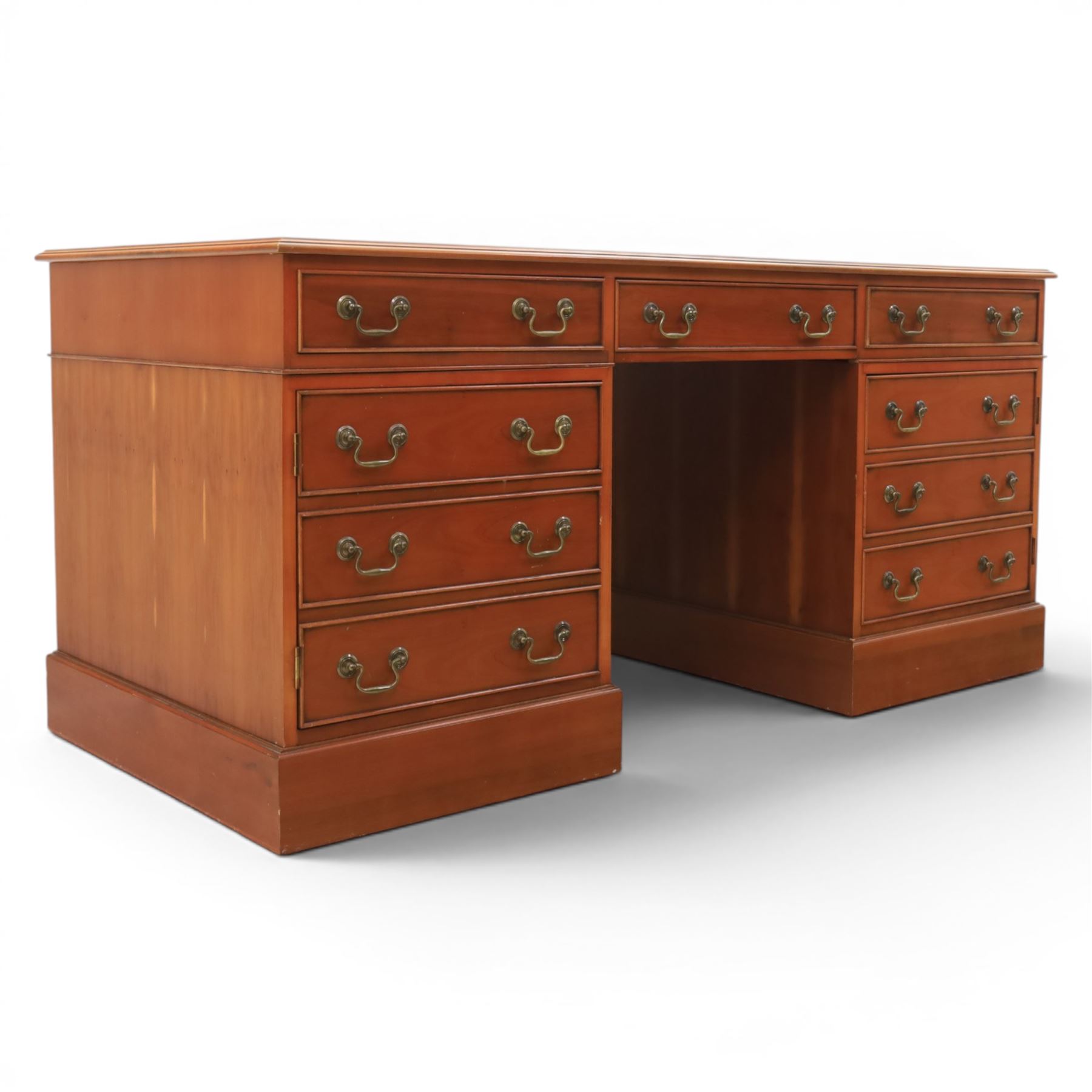 Georgian design yew wood twin pedestal office desk, the top featuring an inset leather writing surface, with drawer drawers and centre keyboard slide, all above two cupboards with slide out shelves