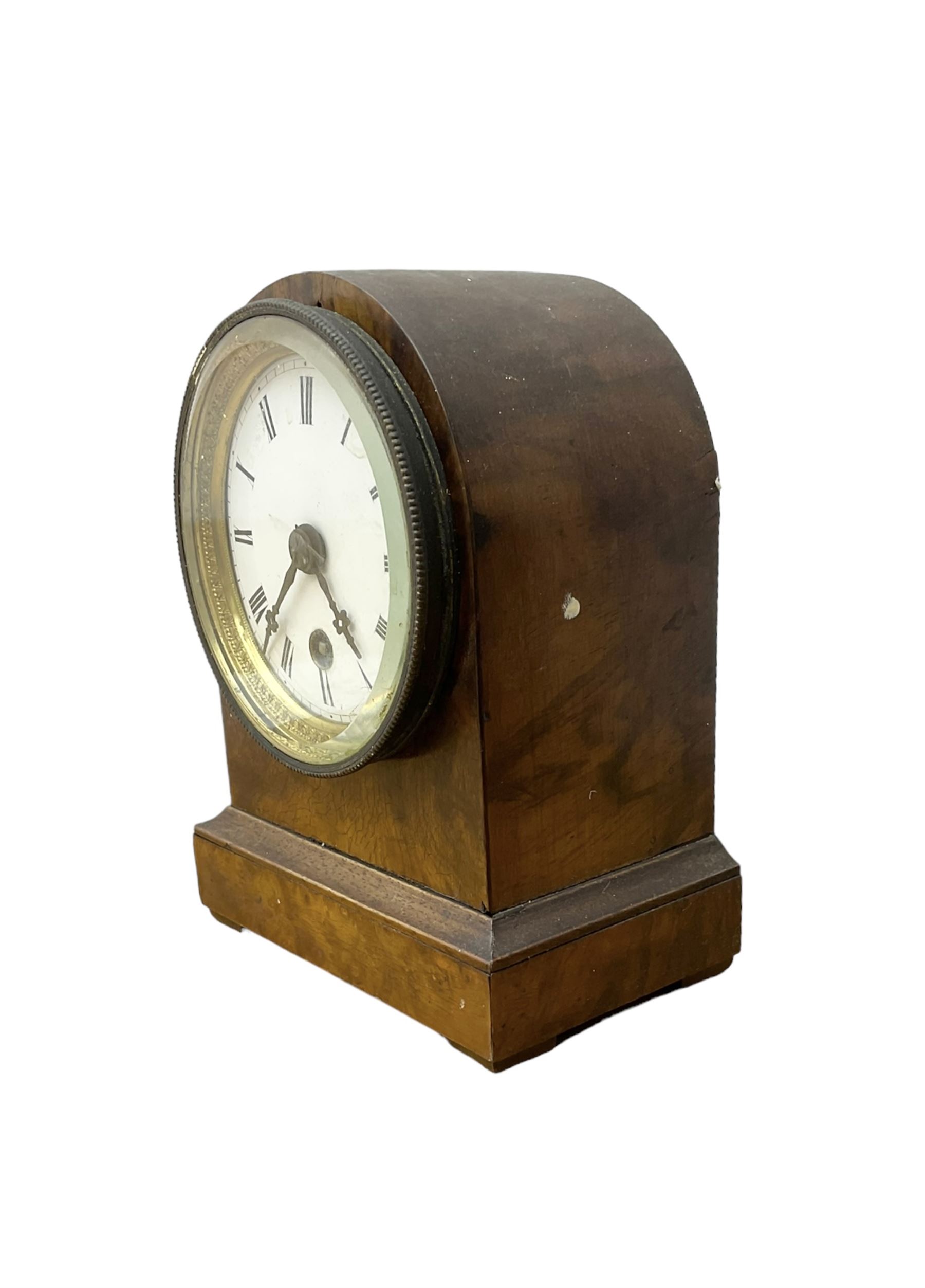 French - late 19th century 8-day walnut table clock, with a round top and shallow plinth raised on block feet, enamel dial with Roman numerals and minute track and decorative pierced steel hands within a gilt slip and cast brass bezel, single train movement with a spring driven going barrel. With pendulum. 