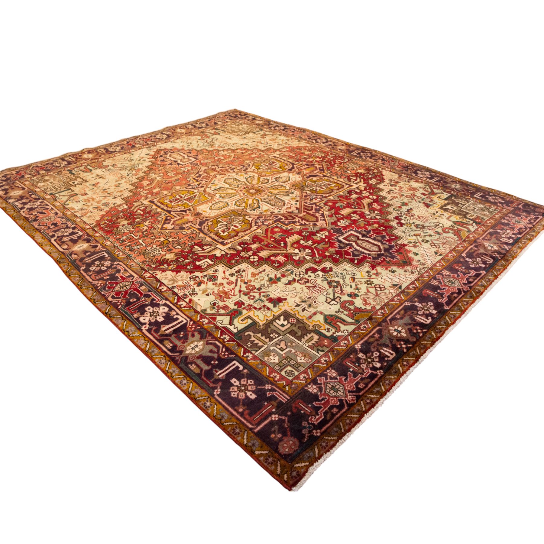 Northwestern Persian Heriz carpet, crimson ground and soft green field, with bold terracotta stepped medallion with angular spandrels and geometric motifs within a broad palmette and vine border 