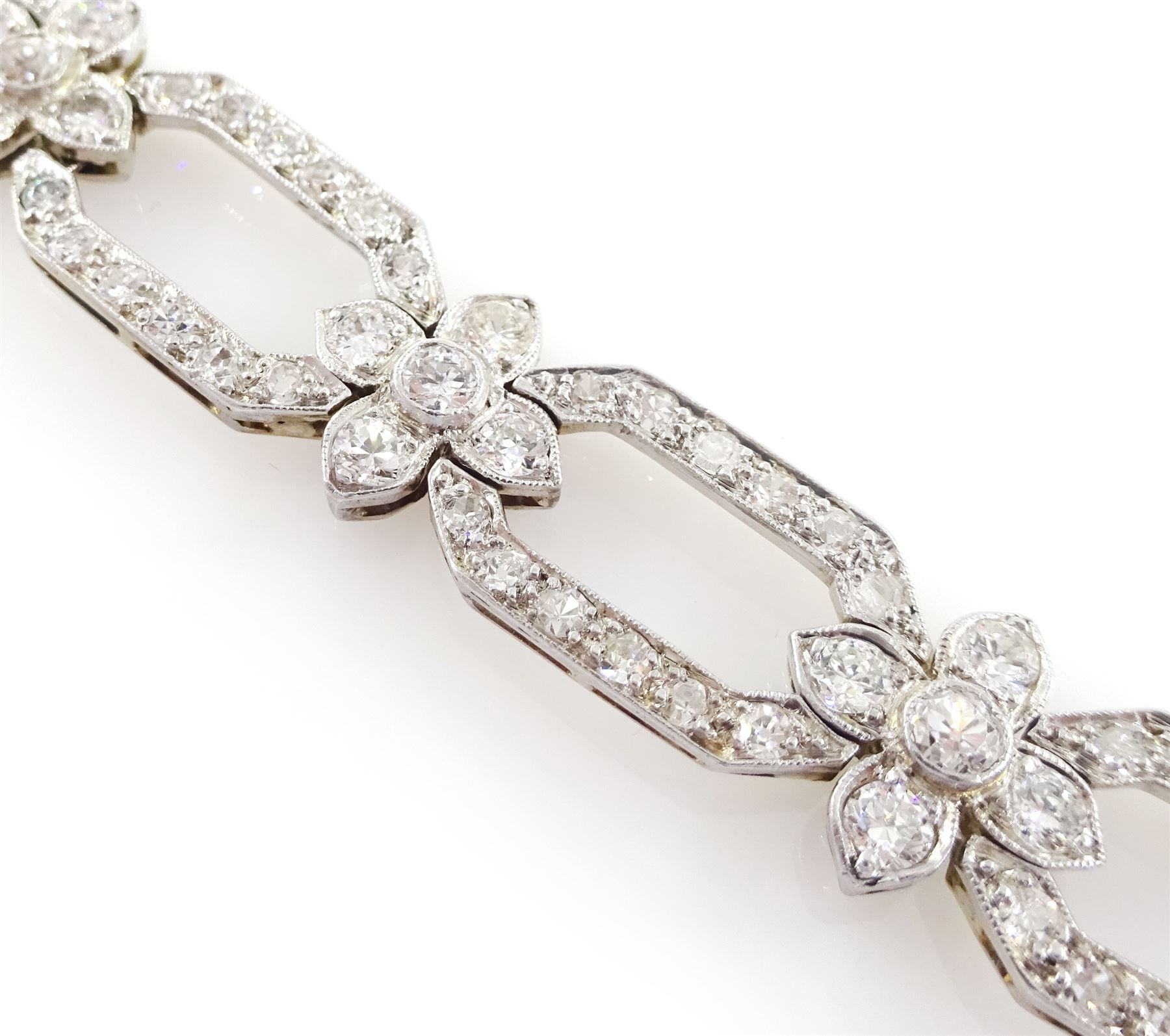 18ct white gold and platinum, milgrain set old cut diamond flower head and openwork panel link bracelet, total diamond weight approx 4.25 carat