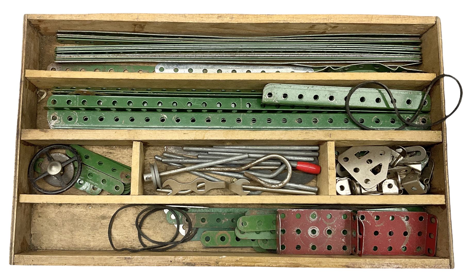 Meccano - wooden box with Set No.5 label to sliding lid, containing two lift-out trays and bottom layer of predominantly red and green sections, wheels, pulleys, rods, tyres etc, carrying handles to either end, L36cm D22.5cm H13.5cm