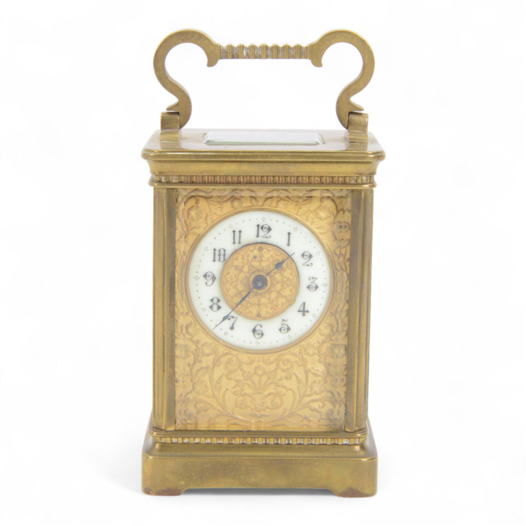 French-Edwardian 8-day timepiece carriage clock with a cylinder platform escapement, anglaise style brass case with four glass panels, dial with a polished gilt mask and foliate decoration, white enamel chapter with Arabic numerals and steel spade hands, . With Key. 