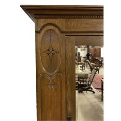 Edwardian oak single wardrobe, projecting cornice over dentil frieze, bevel mirror panelled door enclosing hanging rail and hooks, flanked by oval Art Nouveau decorated panels, single drawer to base