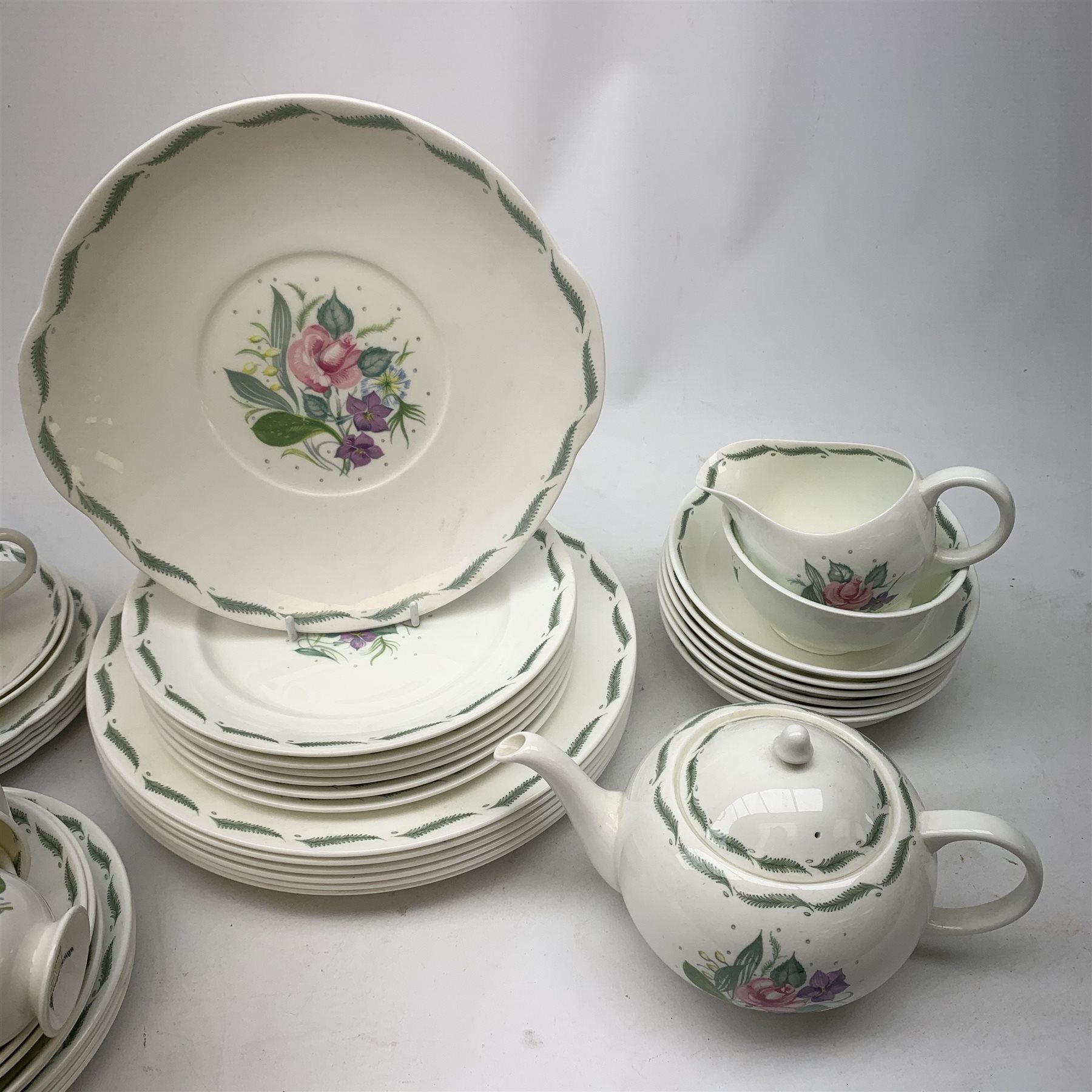 A Susie Cooper for Wedgwood Fragrance pattern tea service, comprising teapot, milk jug, open sucrier, fix teacups, five smaller teacups, five saucers, four further saucers, six side plates, five side plates with frilled rim, a slightly larger side plate, six dessert plates, six larger plates, six bowls, and a sandwich plate. 