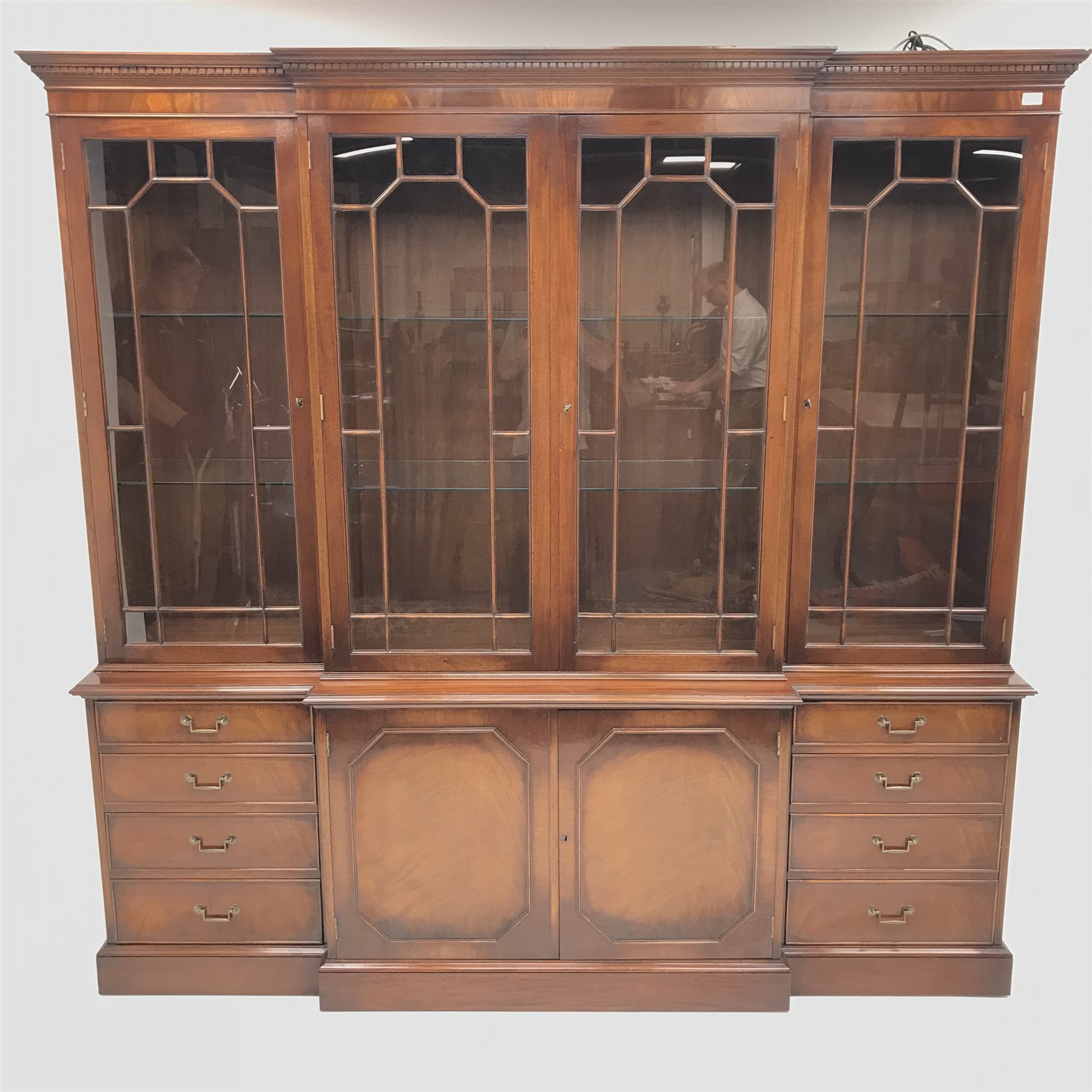 Wade Georgian style mahogany breakfront bookcase display cabinet, projecting cornice, dentil frieze, four doors enclosing six glazed shelves, eight graduating drawers flanking two cupboards, plinth base, W211cm, H203cm, D46cm
