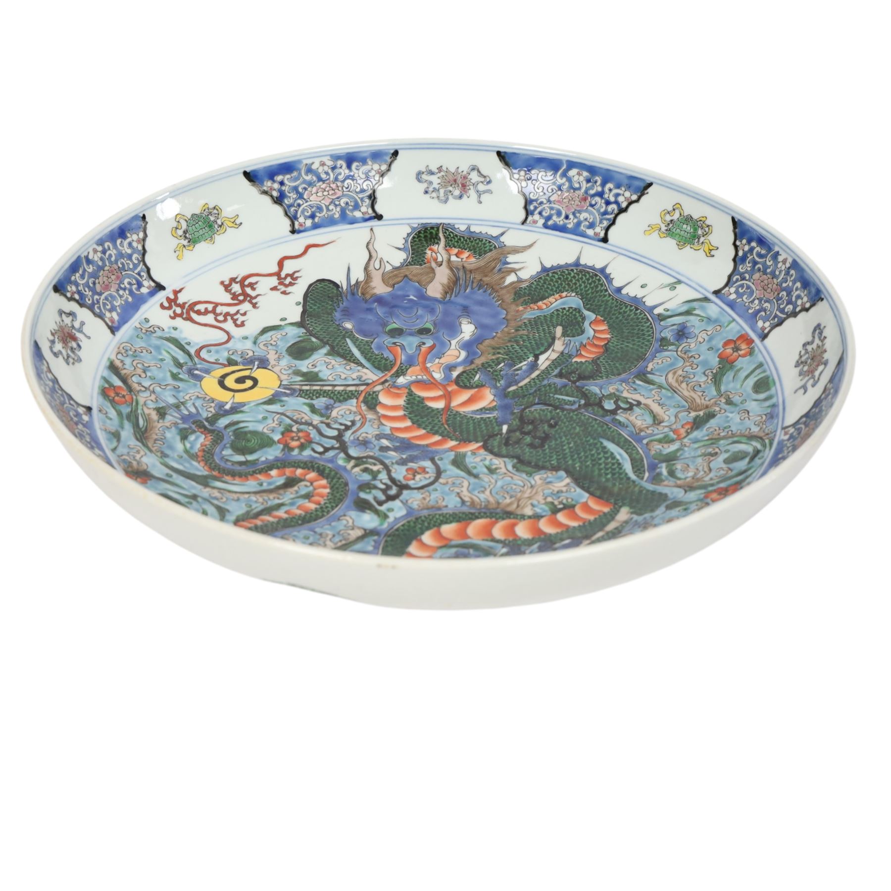 20th century Chinese charger, decorated in blue, green and red enamels with a four clawed dragon chasing the flaming pearl amidst waves and flower heads, the rim with border of alternating reserves of auspicious emblems and flower scrolls, bearing apocryphal Kangxi mark beneath, D38cm 


