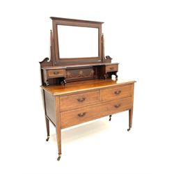 Edwardian inlaid mahogany dressing chest, raised bevelled rectangular mirror above small trinket drawers, the chest fitted with two short and one long drawer, square tapering supports terminating at brass castors