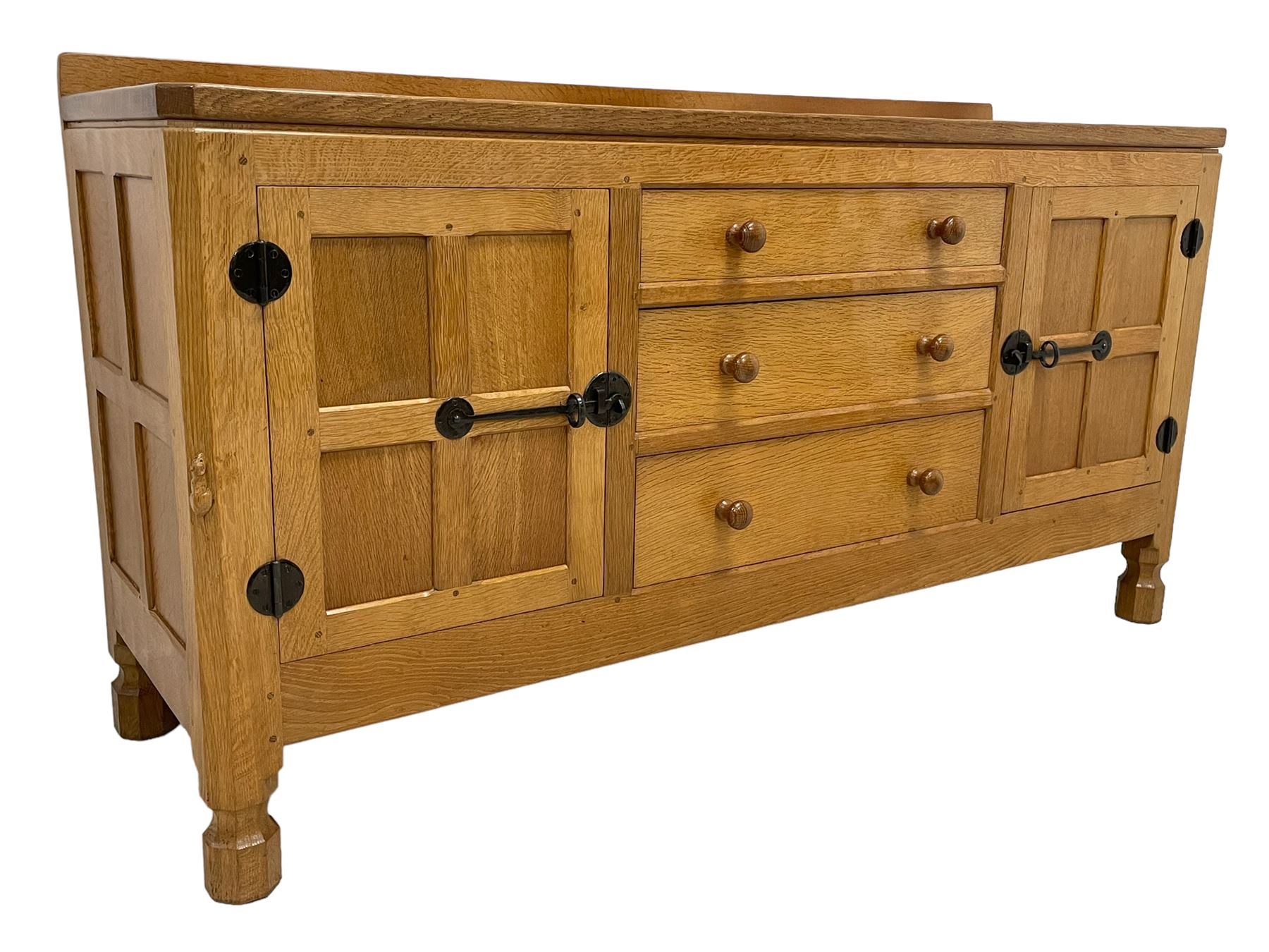 Mouseman - oak dresser, rectangular adzed top with raised back over three central drawers and two flanking cupboards, enclosed by panelled doors with wrought metal fixtures, the canted upright carved with mouse signature, on octagonal feet, by the workshop of Robert Thompson, Kilburn