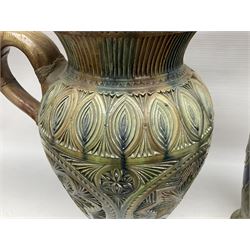Early 20th century Royal Doulton stoneware vase, decorated with a stylized floral design below a wavy rim, monogrammed B.N, possibly for Bessie Newbery, H28cm, together with an early 20th century glazed jug, heavily carved throughout (2)