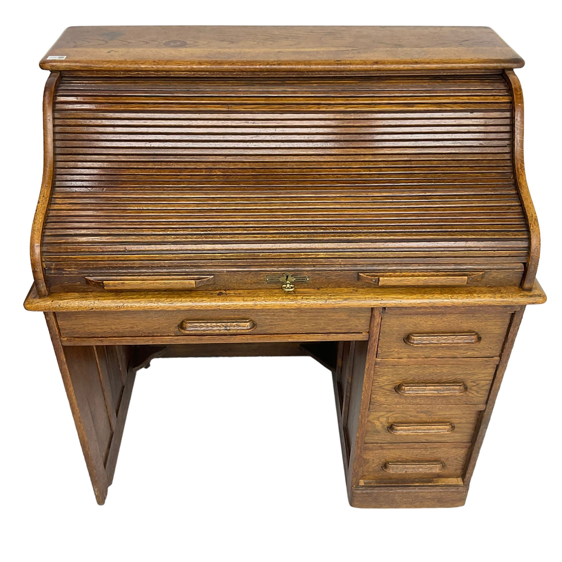 Early 20th century oak roll-top desk, the tambour enclosing pigeon holes and small drawers, the base fitted with slide, a single long drawer and three smaller drawers