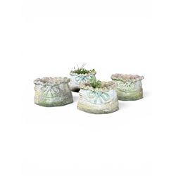Four cast stone garden planters in the form of ribbon tied planting sacks
