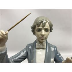 Two Lladro figures, comprising Conductor no 5196 and Prayerful Moment no 5500 together with a Lladro plaque and two Lladro candle holders, Dolphins at Play no 17666 and Sailing the Seas no 17665, all with original boxes, largest example H33cm 