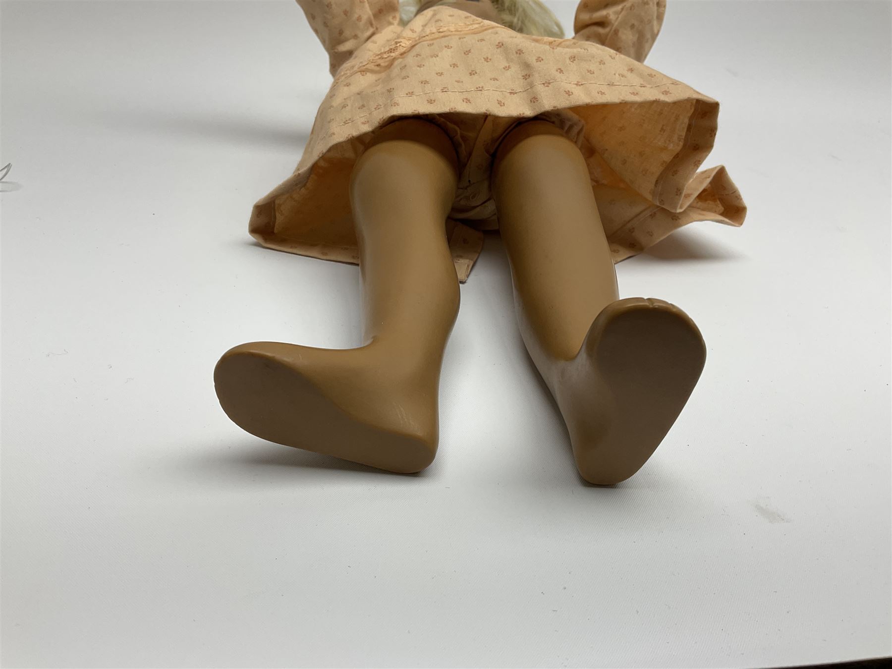 Sasha Morgenthaler vinyl doll, the girl's head with painted blue eyes and lips and short blonde hair, the jointed body donning a peach floral dress with matching underclothes, unmarked, H41cm