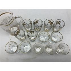 Mid 20th century glass part lemonade set comprisimg jug decorated with white floral sprays and gilt banding with three matching cups, together with a set of six tumblers decorated in black and gilt with flowers and set of four other glasses