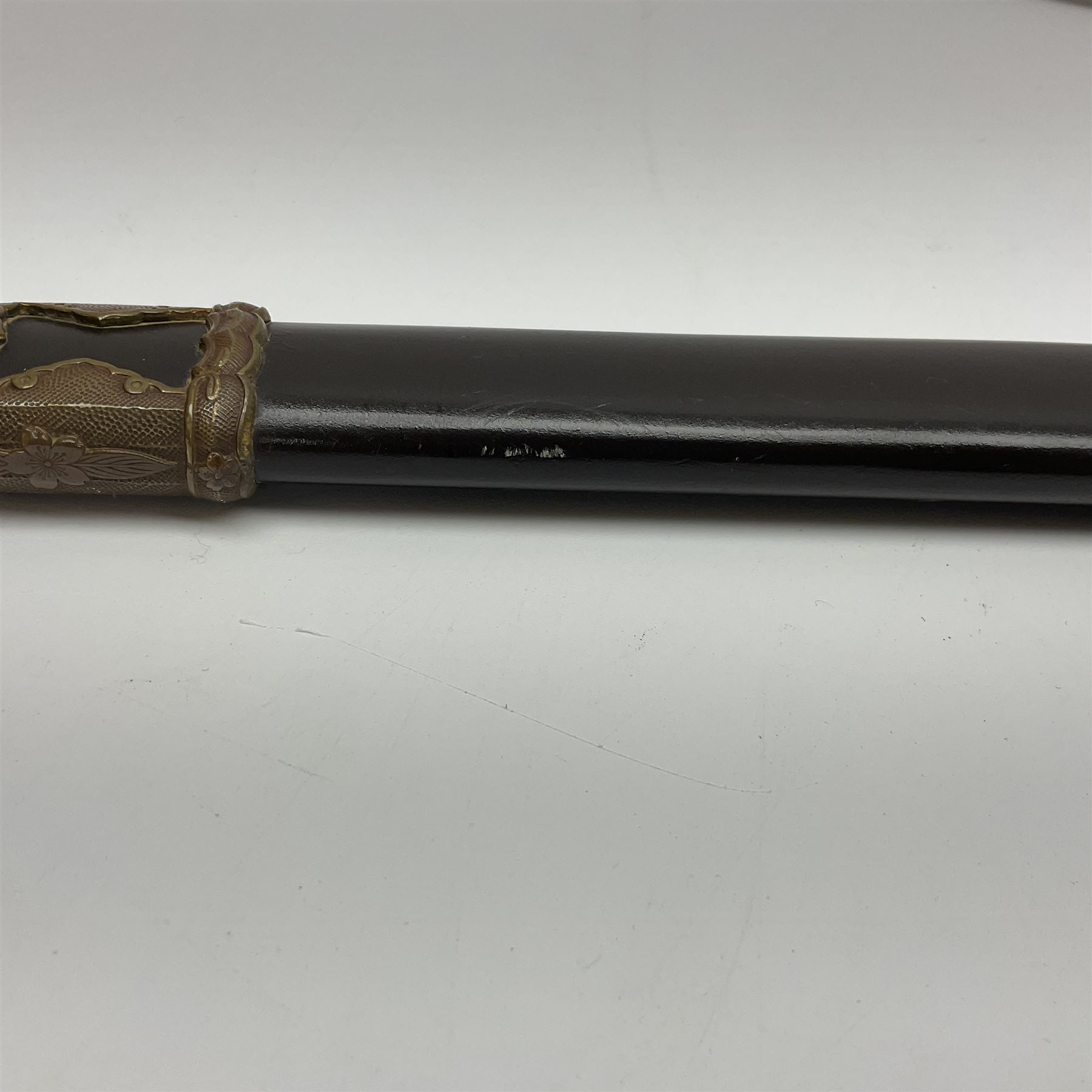 WW2 Japanese Army officer's shin gunto/katana sword with 68.5cm steel single edged blade, foliate cast brass tsuba, bound fish-skin grip with brass mounts, inscribed marks to both sides of tang; in lacquered wooden scabbard with brass mounts and locking button L97cm overall