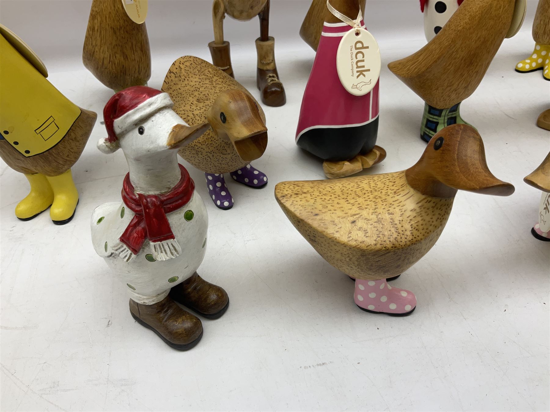 Quantity of the Duck Company UK DCUK carved bamboo root ducks, modelled wearing rain hats and rain boots etc, together with other similar carved wood ducks, tallest H26cm