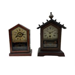 An American spring driven 30-hour 19th century timepiece shelf clock in a wooden case with a gable top and finial, decorative glass door with a white painted dial, roman numerals and minute track, with steel spade hands. No pendulum or key.
H33 W20 D12
With a similar design of spring driven 30-hour 19th century American shelf clock with an alarm, white painted dial with Roman numerals and minute track, steel spade hands with brass alarm setting disc to the centre.
With pendulum and key.
H24 W18 D9
