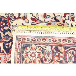Two Persian rugs, Persian Hamadan hand-knotted rug, ivory ground centred by a terracotta medallion, surrounded by scrolling floral and foliate motifs, dark navy floral border with narrow guard stripes, fringed ends, H 176cm, W 75cm, Persian tribal hand-knotted rug, madder red ground decorated with three large geometric medallions, surrounded by angular motifs, enclosed by multiple geometric borders in dark navy, ivory and red, fringed ends, H 150cm, W 91cm