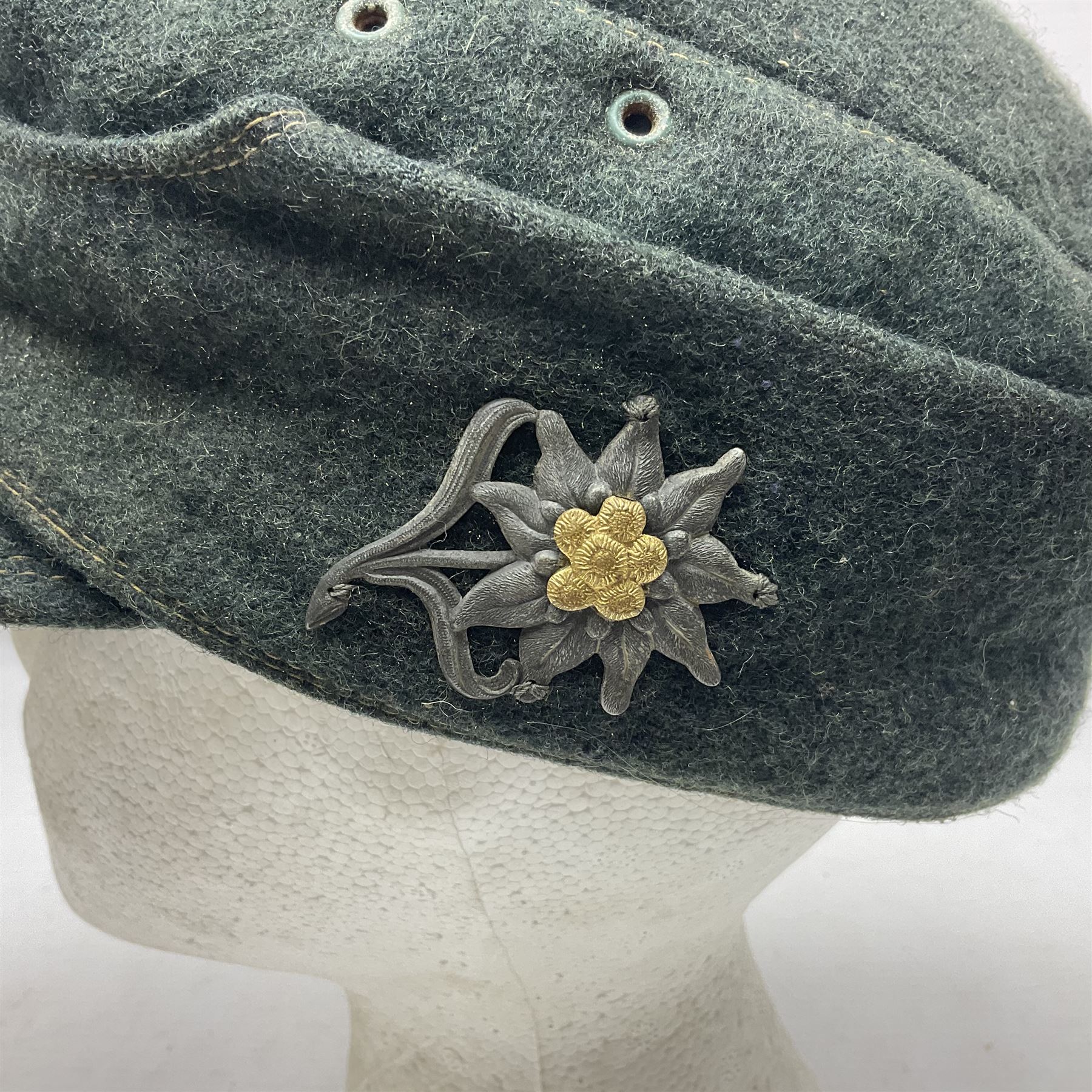 WWII German M43 field cap with 'SS' cloth badge and mountain trooper's edelweiss metal badge