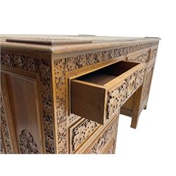 Large Indian hardwood twin pedestal desk, heavily carved with foliate decoration, one side fitted with two drawers and the other fitted with six drawers and cupboard,