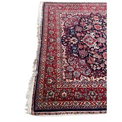 Persian Hamadan indigo ground rug, central floral crimson pole medallion surrounded by trailing foliate decoration and stylised plant motifs, the main guarded border with repeating stylised flower heads, densely knotted