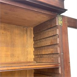 Early 19th century figured mahogany bureau bookcase, projecting splay moulded cornice over three adjustable shelves enclosed by two glazed doors, fall front revealing pigeonholes, cupboard and drawers, pull-out strays with scroll carved terminals, double cupboard with two panelled doors, on turned feet 