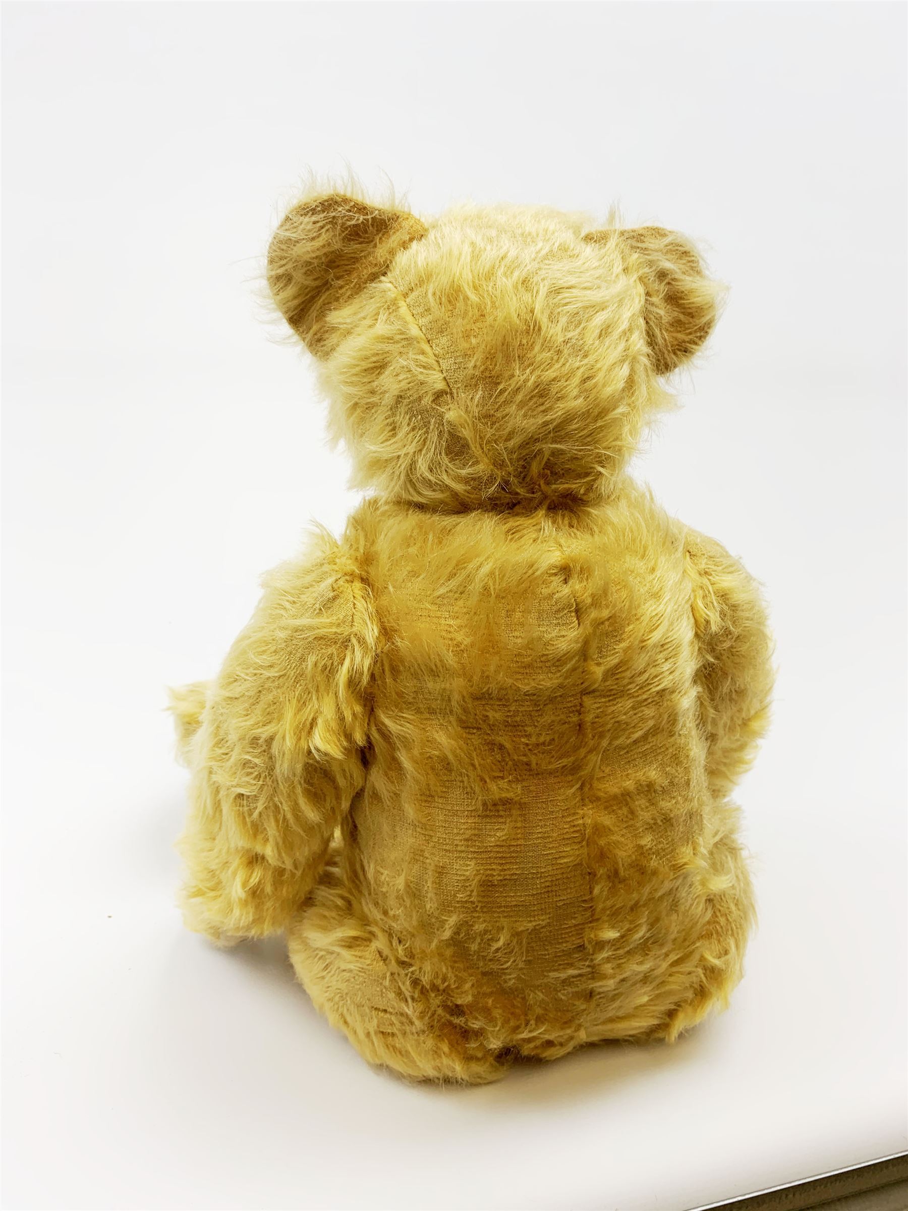 Alpha Farnell Toys large blonde mohair teddy bear with glass eyes, vertically stitched nose and mouth and jointed limbs with stitched claws, label to right foot pad H23.5