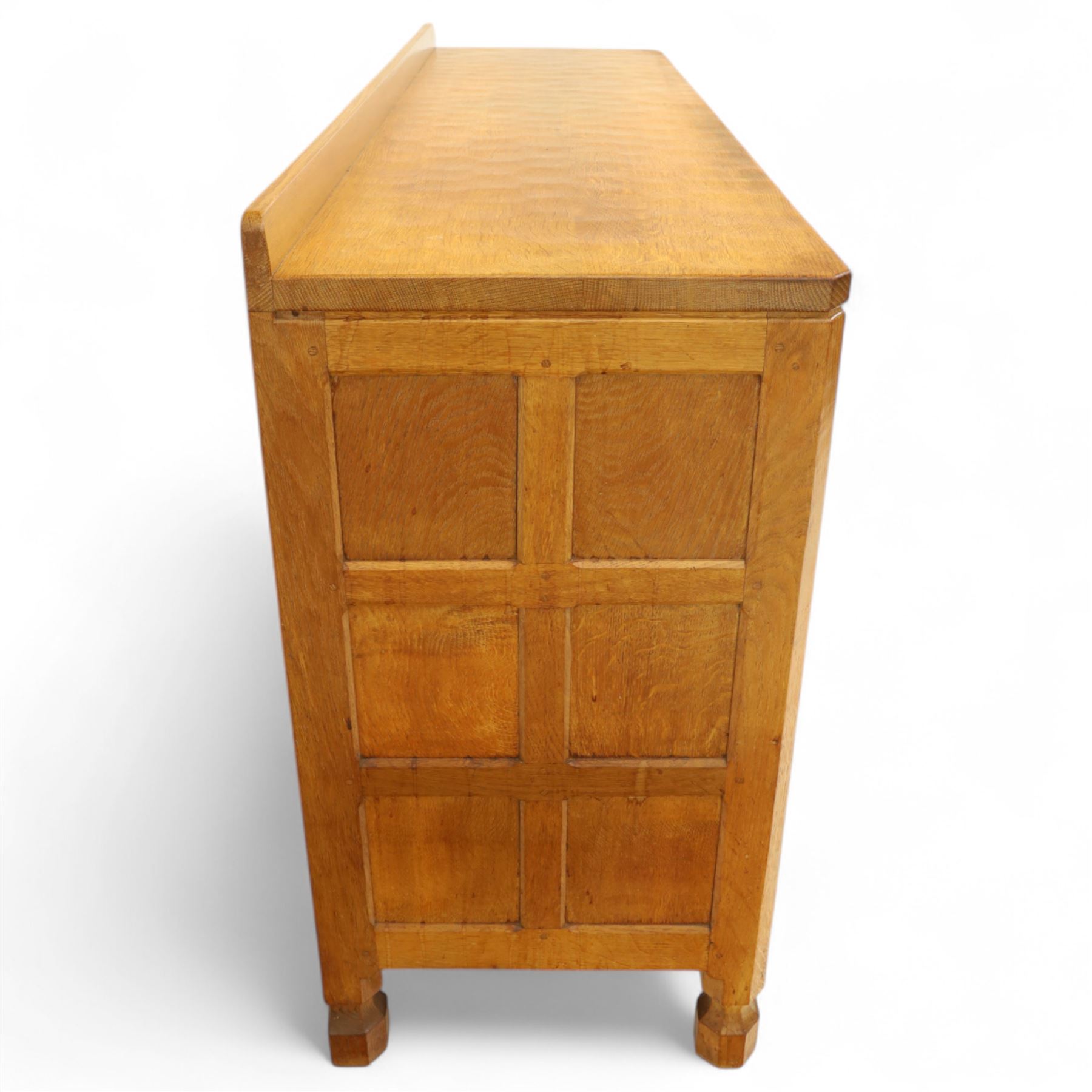 Mouseman - oak sideboard with adzed top and raised gallery back, over two short drawers and three long drawers, flanked by panelled cupboard doors with wrought iron fittings, on octagonal feet, carved with the signature mouse to the right-hand door
