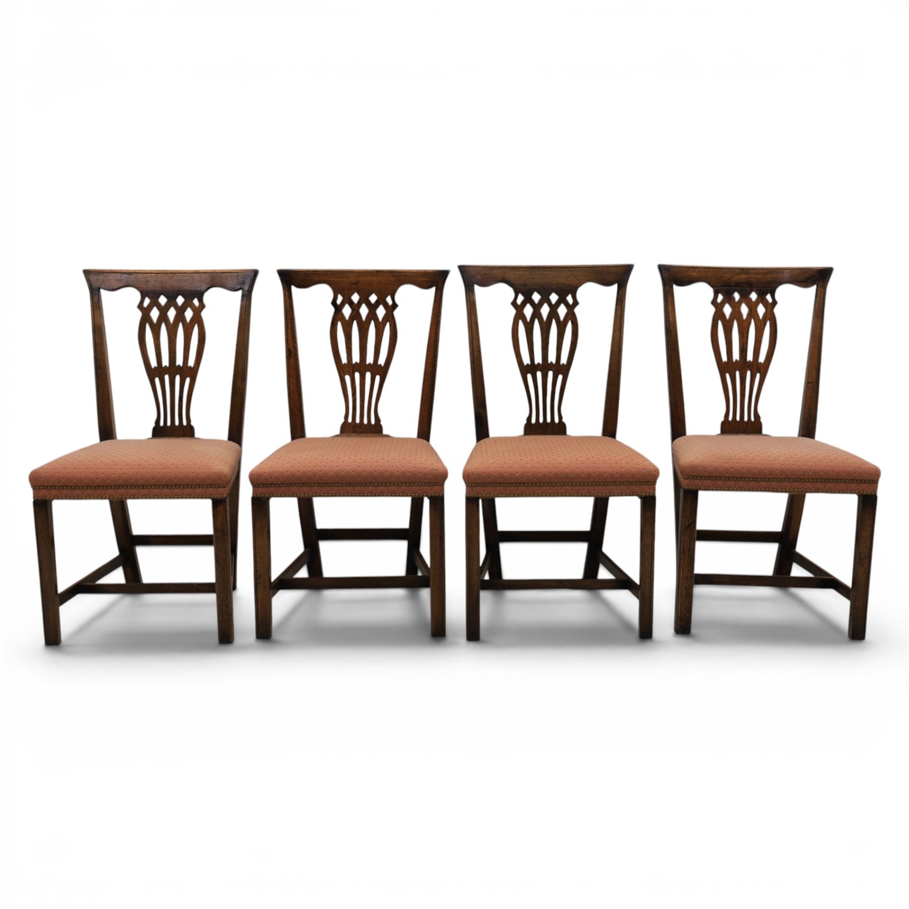 Set of eight George III dining chairs with padded seats, pierced vasiform splat, upholstered seat with brass trim, on square supports with H-stretcher