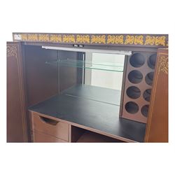 Chinese brown lacquered cocktail cabinet, decorated with gilt scenes of a traditional landscape with figures, pagodas, and mountainous scenery, double doors opening to reveal fitted interior with mirrored back, wine rack, shelves and cupboard, raised on square supports