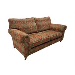 Duresta - 'Beaminster' grande two-seat sofa, traditional shape with rolled arms, upholstered in 'Althorp' russet and stone floral pattern fabric, on turned feet with brass castors
