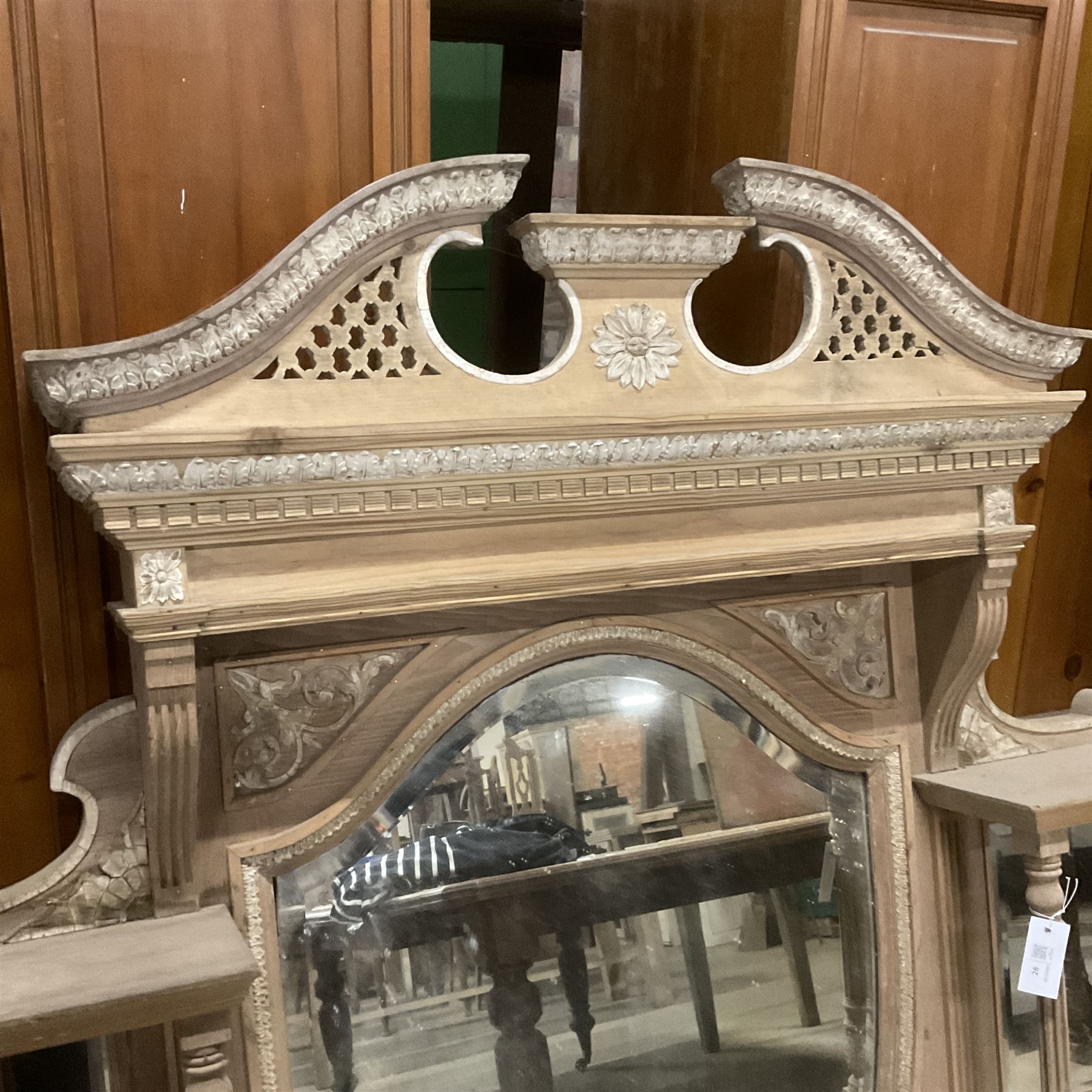 Late 19th century pine and gesso mirror back or wall mirror, pierced broken swan neck pediment decorated with foliate and central flower head motif, shield shaped bevelled mirror, the spandrels decorated with scrolled foliate decoration, two tier shelves on turned and fluted supports  - THIS LOT IS TO BE COLLECTED BY APPOINTMENT FROM THE OLD BUFFER DEPOT, MELBOURNE PLACE, SOWERBY, THIRSK, YO7 1QY