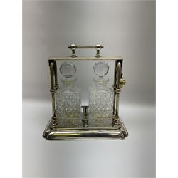 Early 20th century silver plated tantalus by John Grinsell & Sons of Birmingham, containing two crystal glass decanters, with key, H31cm
