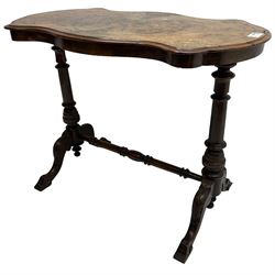 Victorian figured walnut stretcher table, shaped moulded top with quarter matched veneers inlaid with boxwood stringing and trailing foliate, on twin turned pillar supports united by turned stretcher, on acanthus carved splayed supports 