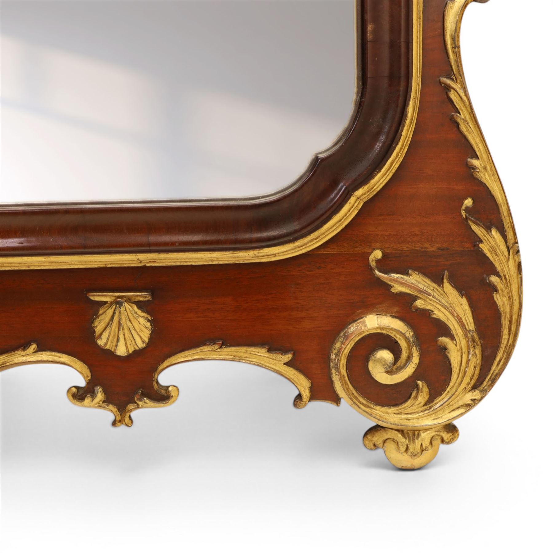 Large George III mahogany wall mirror, parcel gilt shaped frame with scrolling acanthus, shell and foliate decoration, surmounted by carved gilt ho-ho bird, rectangular mirror plate within moulded border, shaped apron with gilt scroll terminals, removed from a Scottish country estate