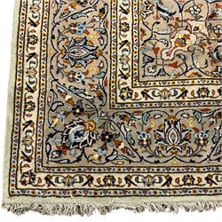 Persian Kashan carpet, light ground and decorated with interlacing branch  and stylised flower head motifs, repeating border