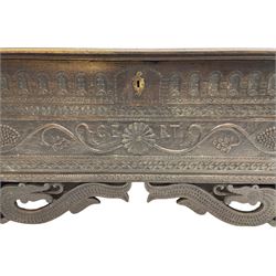George III oak blanket box or kist, moulded rectangular top over hinged fall-front, with arcade frieze and central flower head with extending trailing branch and foliage, within a border carved with flower heads, initialled 'C.E R.T', fitted with wrought metal carrying handles, scaled serpent carved lower brackets, on sledge feet